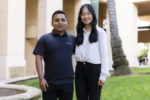 Two students pose outside the business building