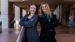 Shannon Fast and Kelly Dye posing in a breezeway at Orfalea