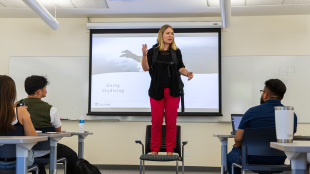 Kim Westermann stands on a chair in class to give her "skydiving" scenario