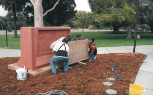 Workers install the Orfalea College of Business sign