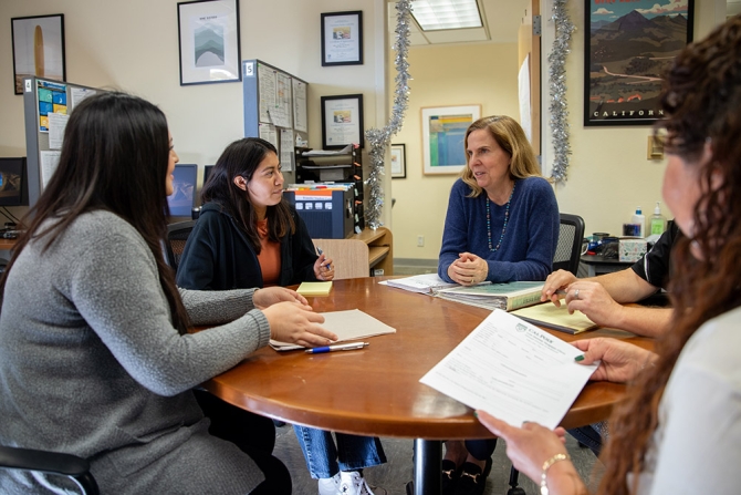 Lisa Sperow sitting at a table with students.
