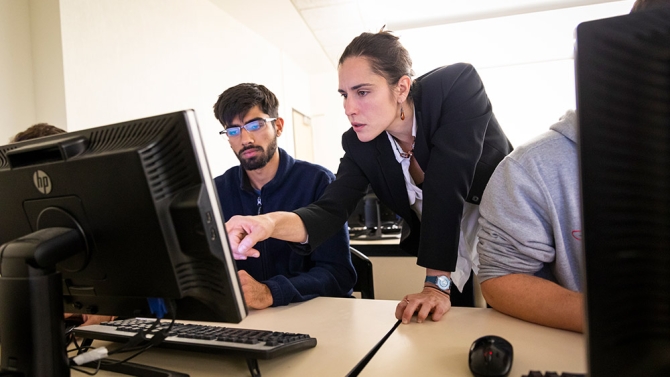 Teacher helping student on computer