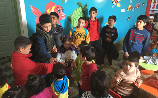 Ibrahim Hassen hands out treats to Syrian children