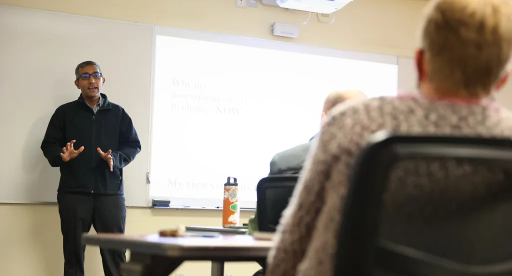 A professor speaks to peers in a classroom