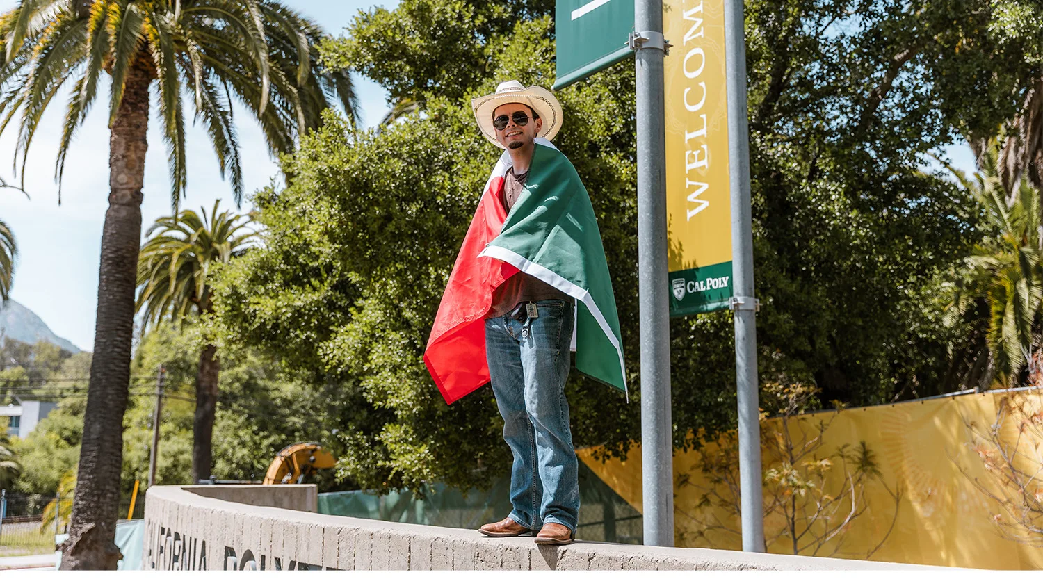 Student poses with Mexican flag around shoulders