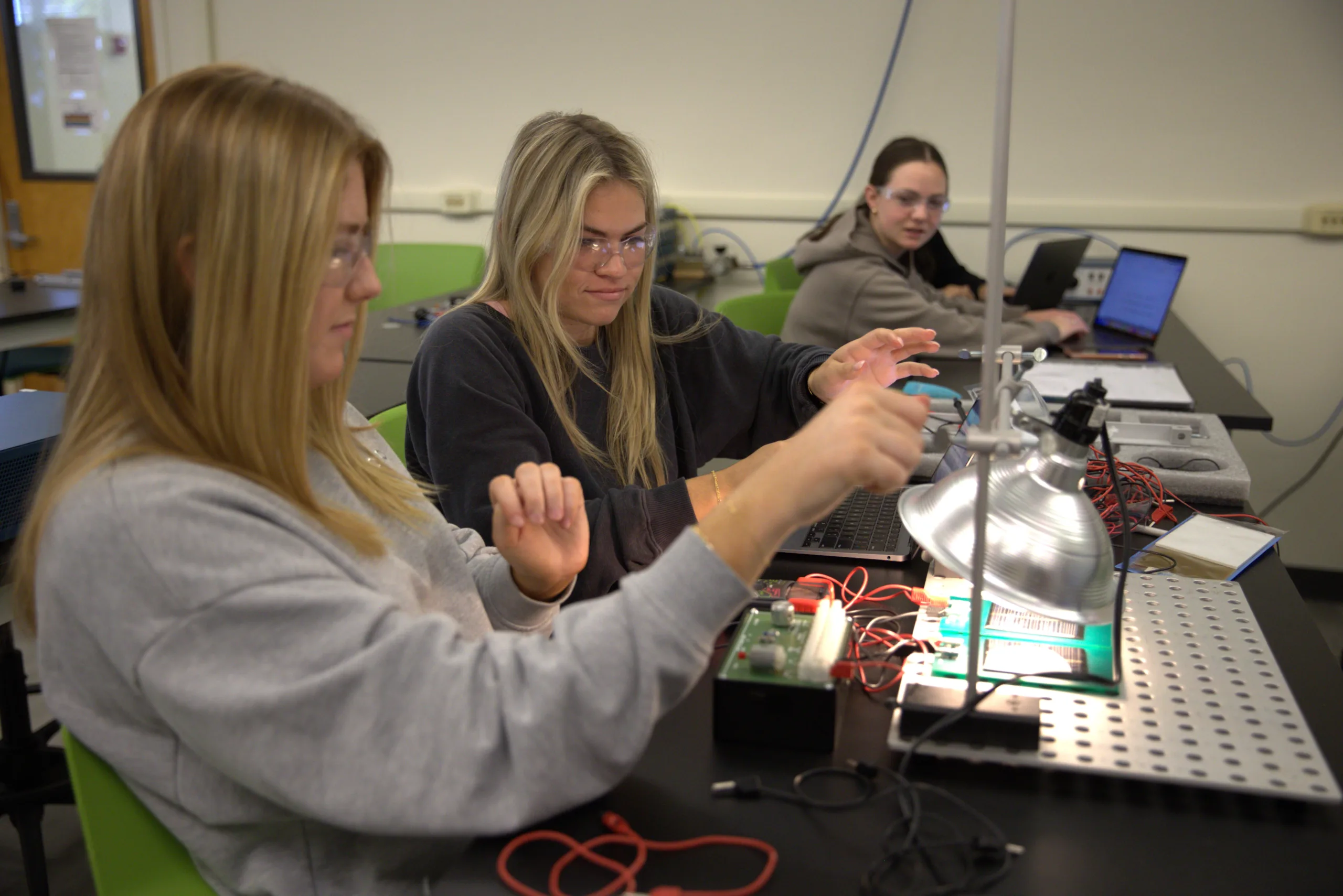 Students work with electrical wires in a lab