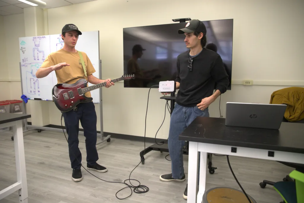 Students demonstrate a guitar tuner they created