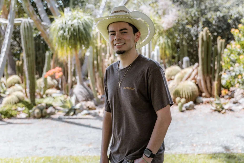 Humberto Mejia poses near a cacti garden