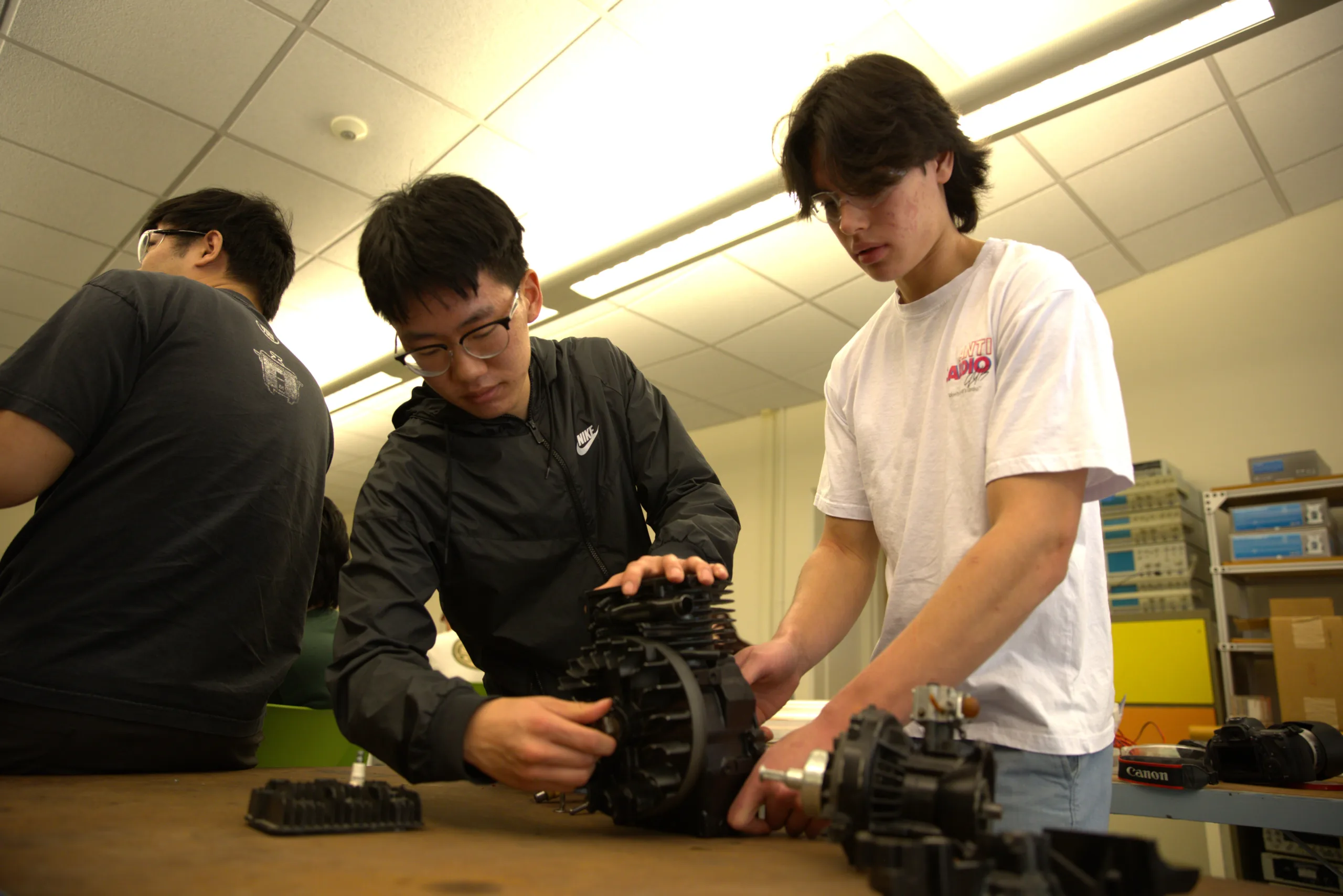 Students work on a small engine in a college lab