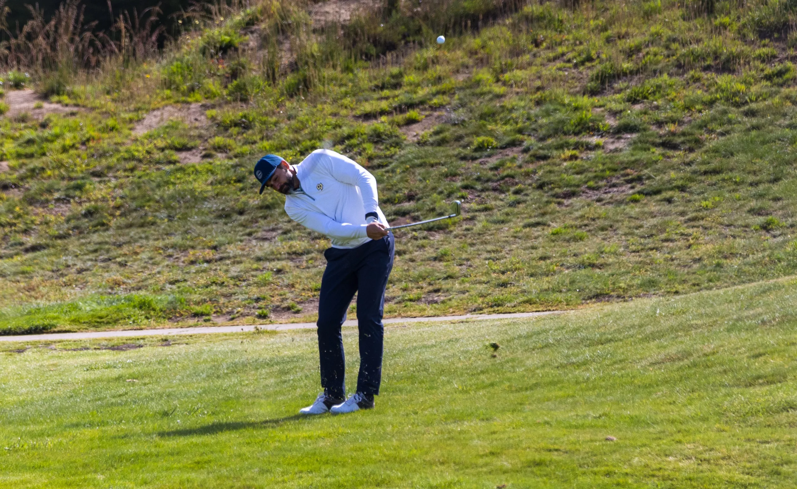 A golfer hits the ball on the fairway