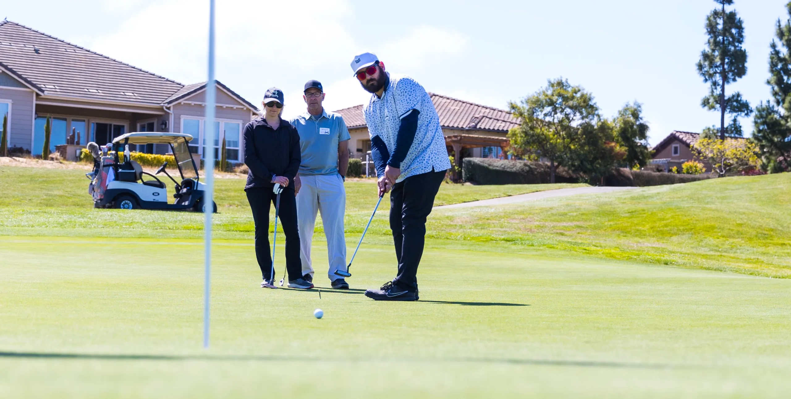 A golfer putts near the hole