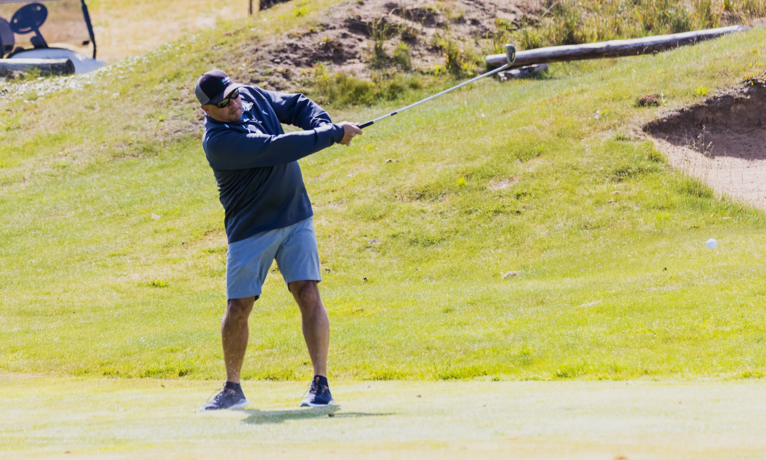 A golfer hits an iron shot