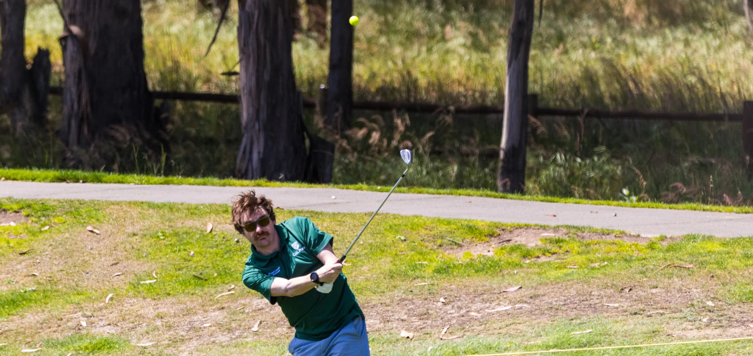 A golfer makes a short shot skyward