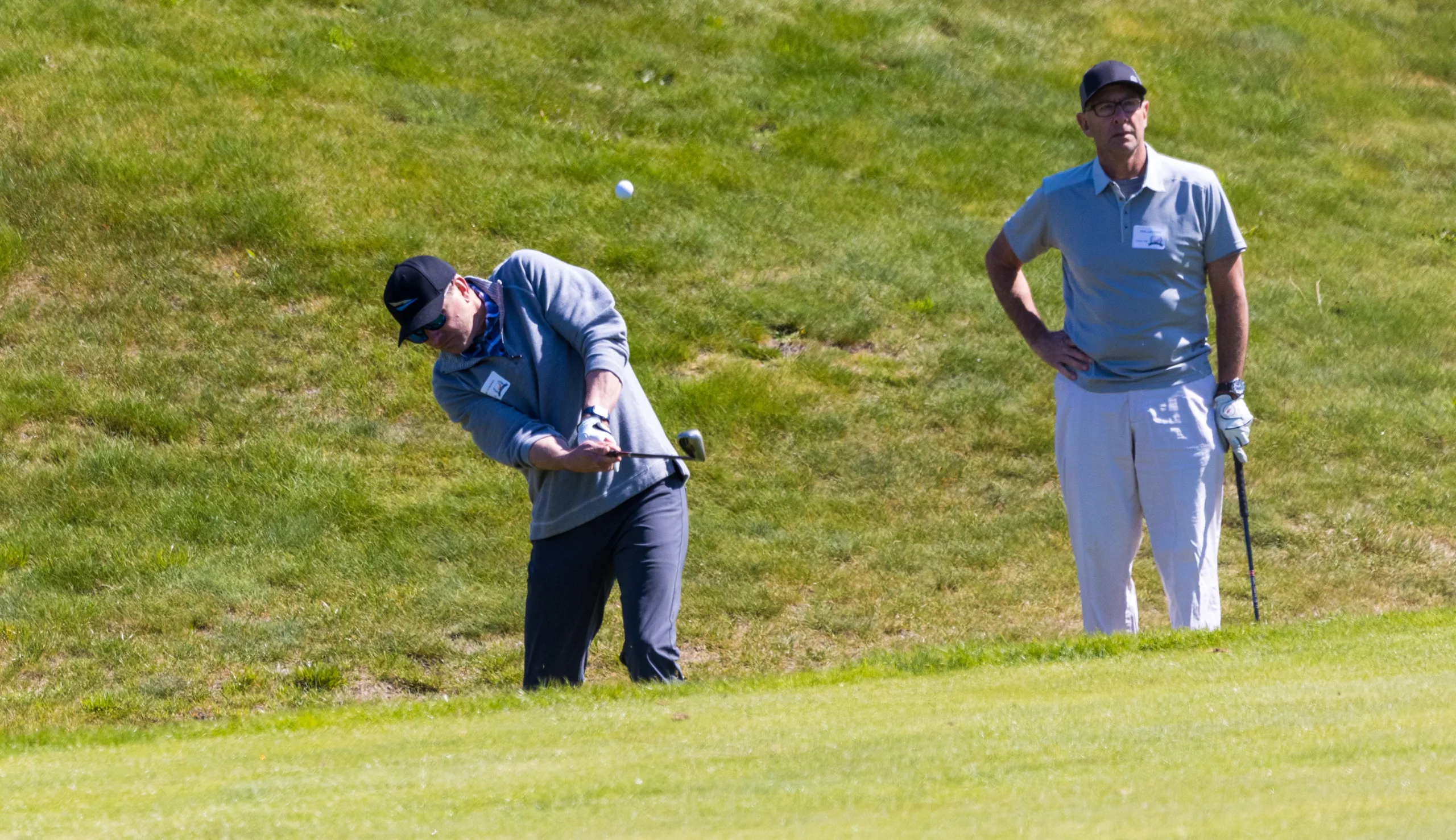 A golfer chips near the green