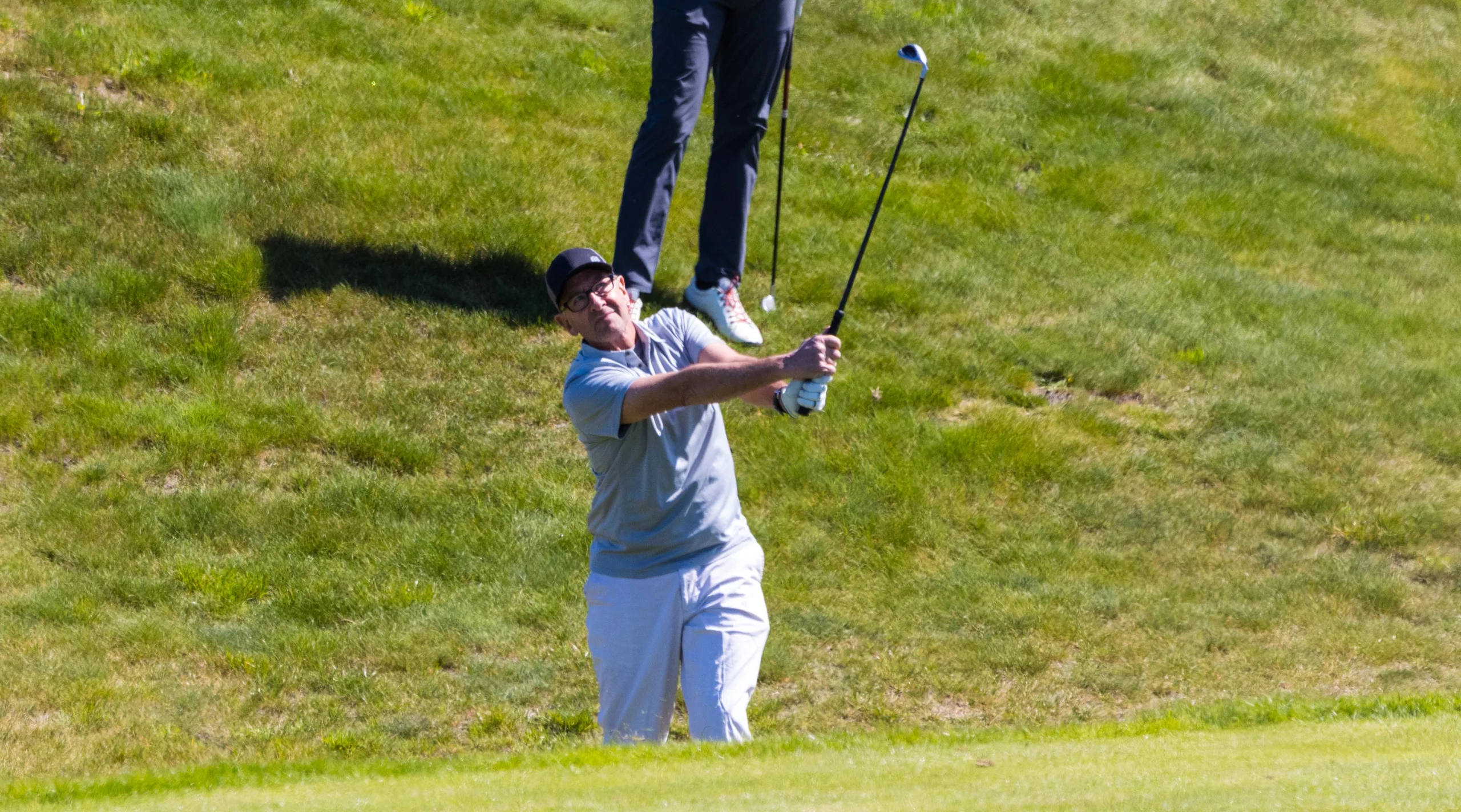 A golfer looks skyward toward his ball