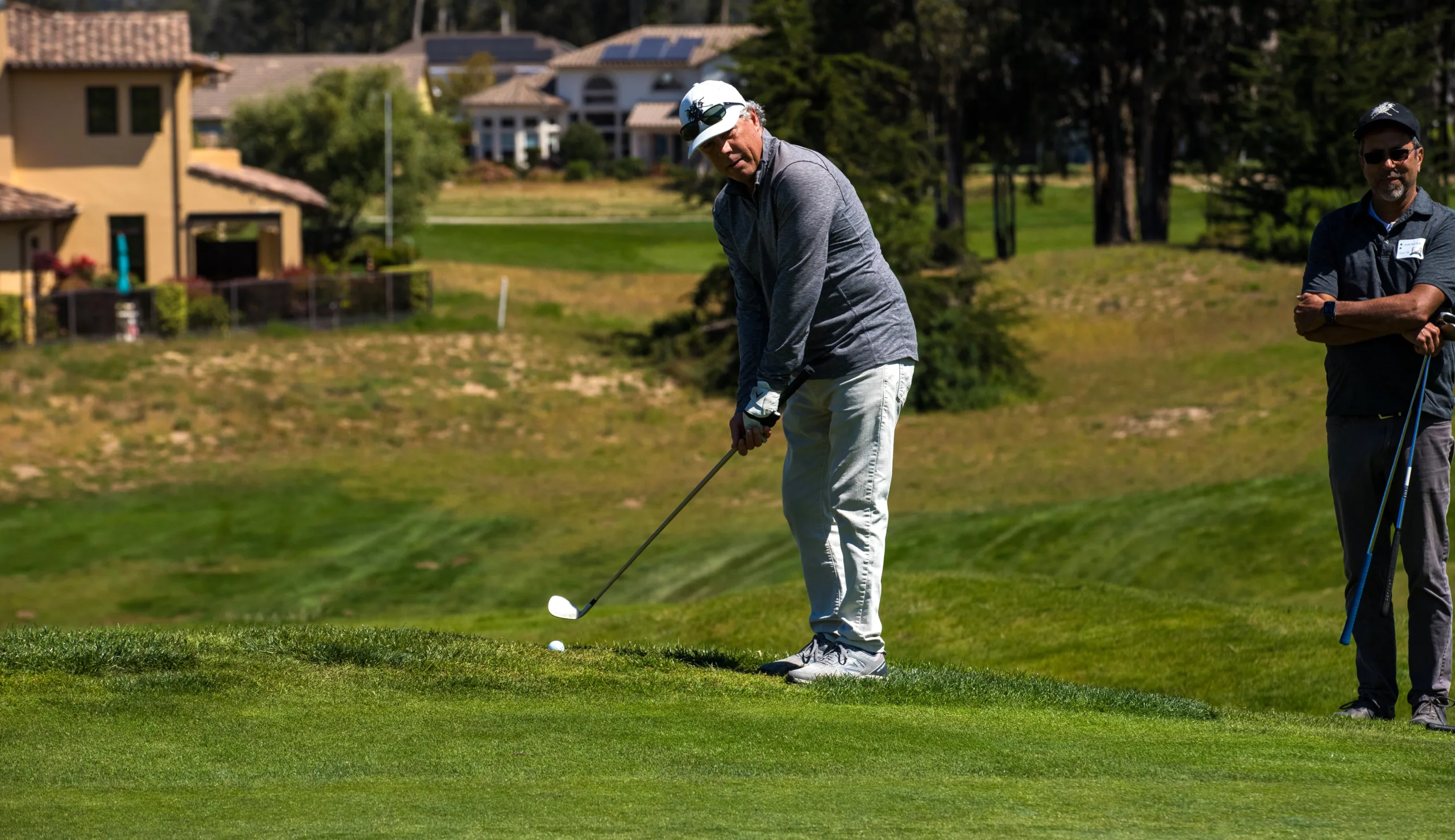 A golfer chips toward the green