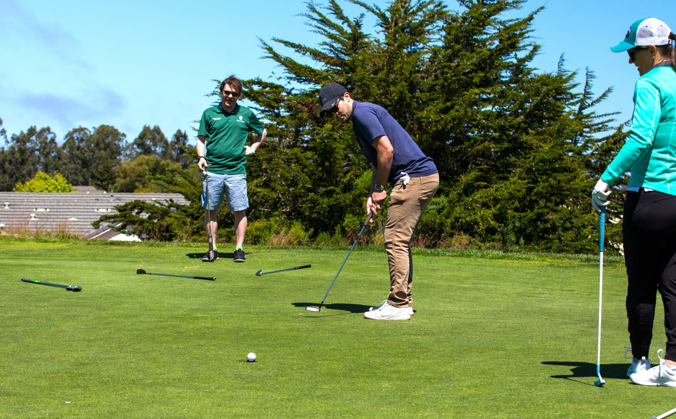 A golfer putts on the green