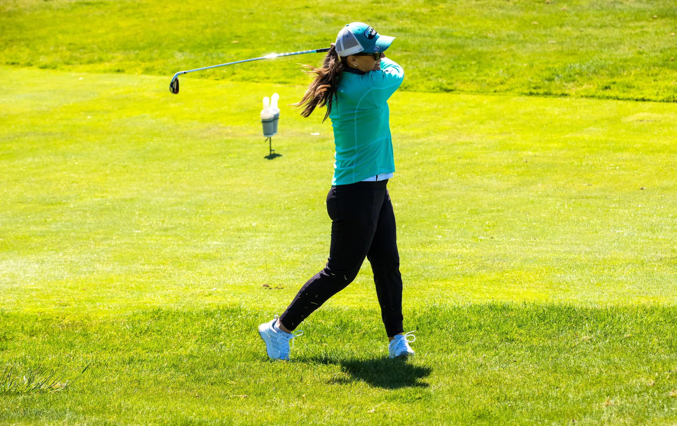 A golfer swings on the fairway