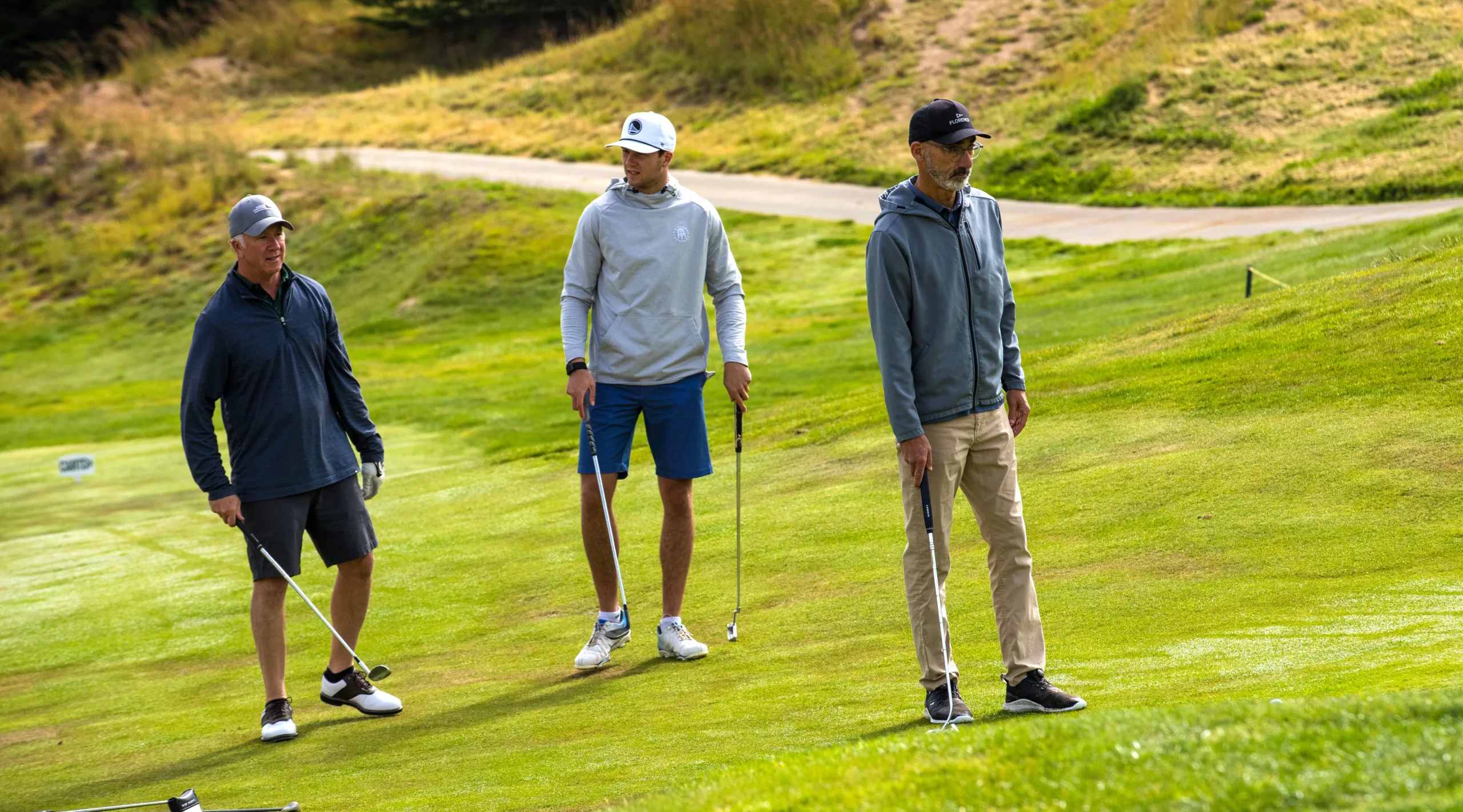 Three golfers discuss the next shot