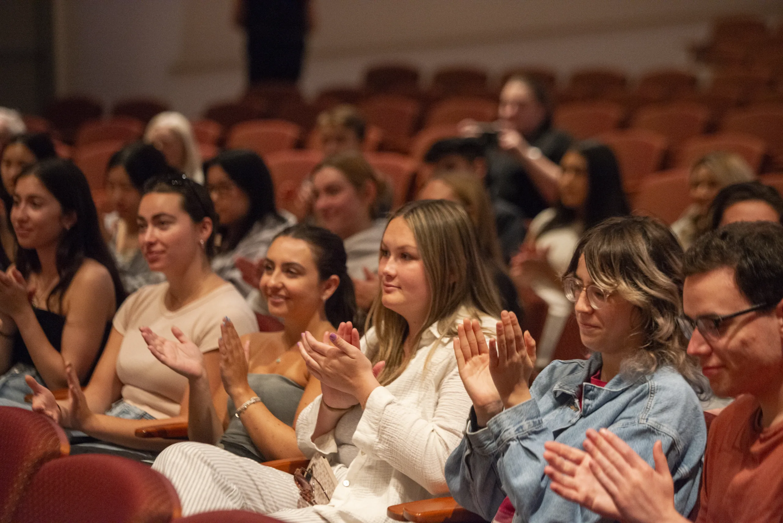 Members of an eudience applaud a speaker