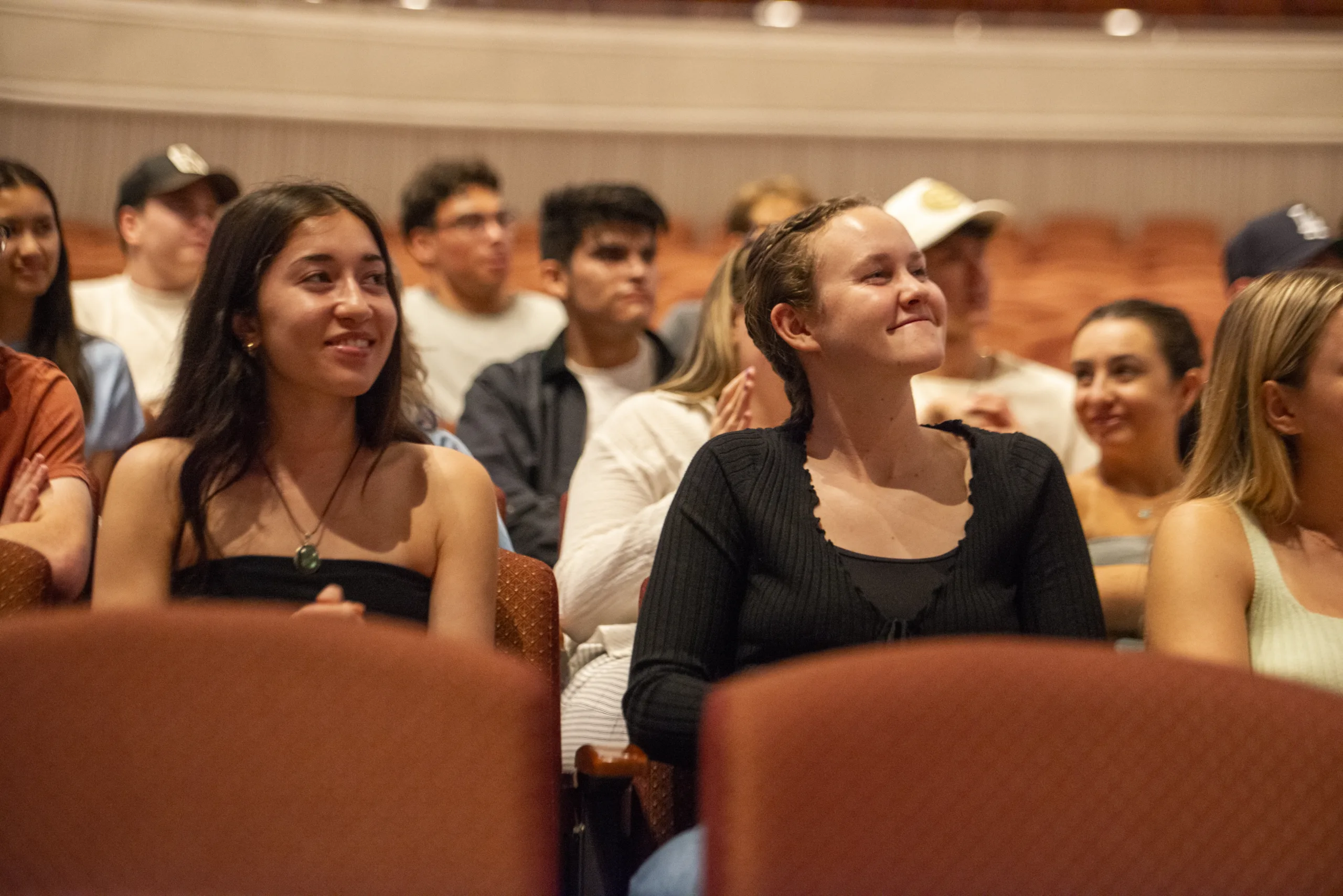 Audience members smile during a performance