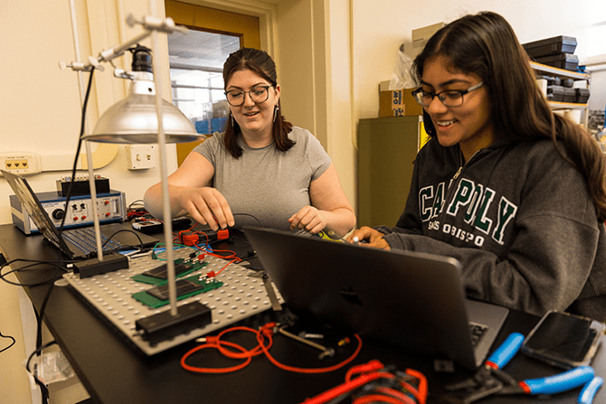 Students in a freshman-level Industrial Technology and Packaging work on a project demonstrating electricity.