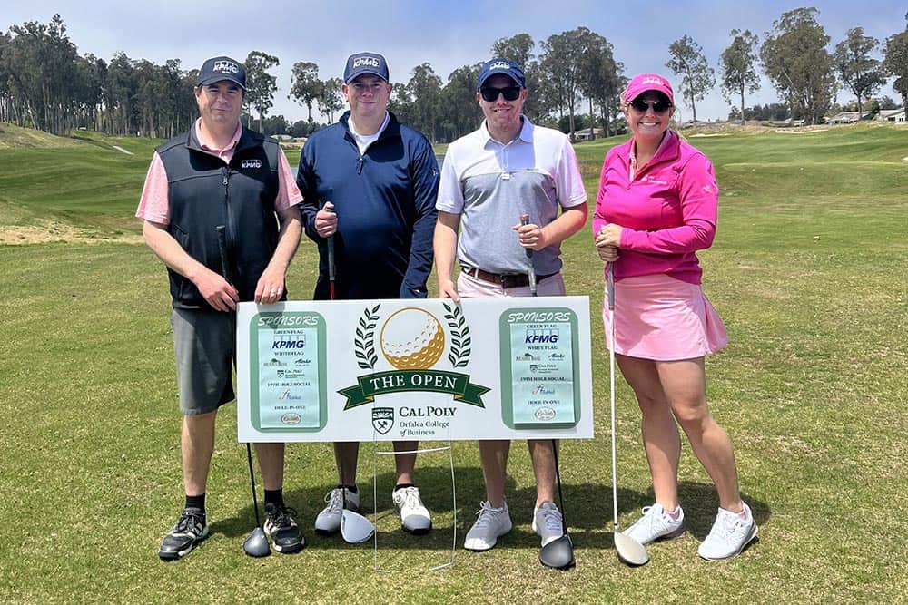 Group of golfers pose for photo behind fundraising sign