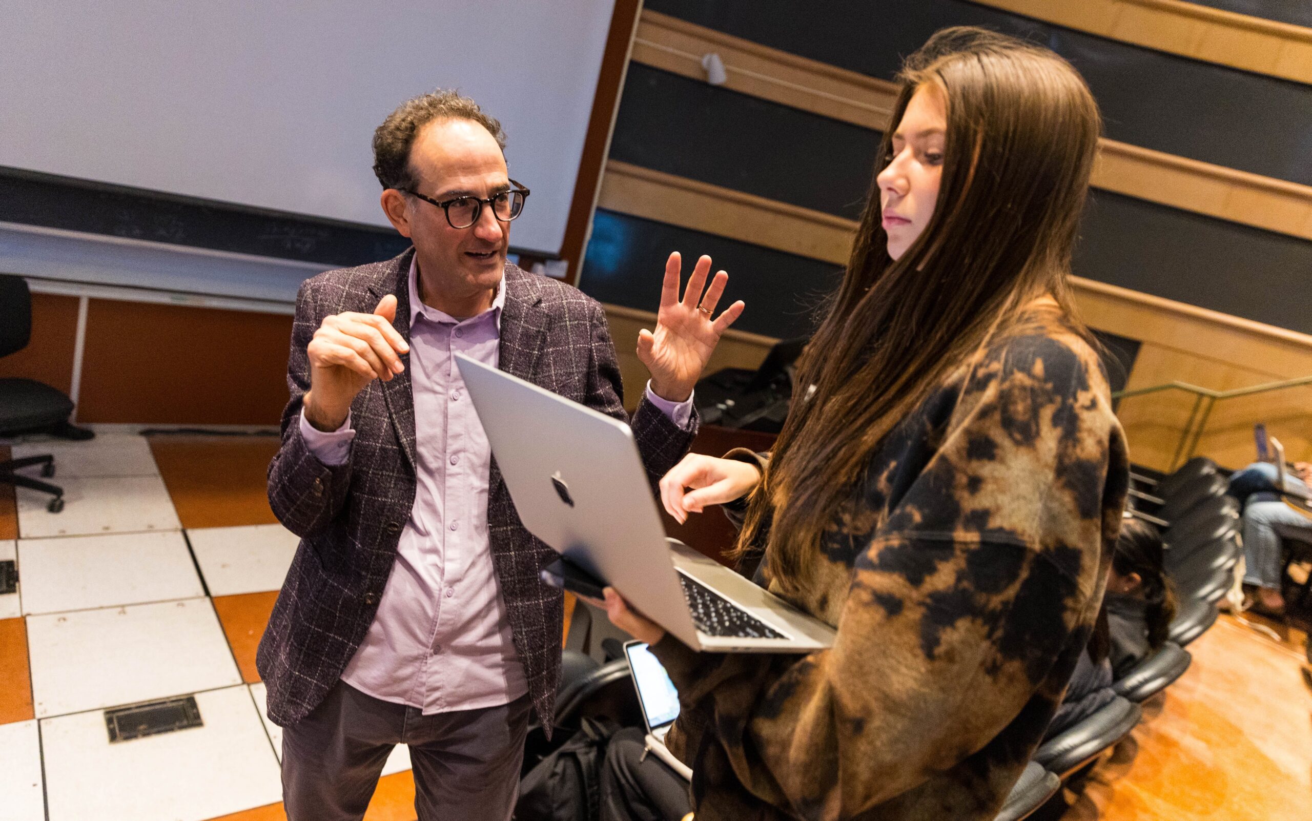 A student works on a project in Stern Neil’s marketing class, with Neil offering advice