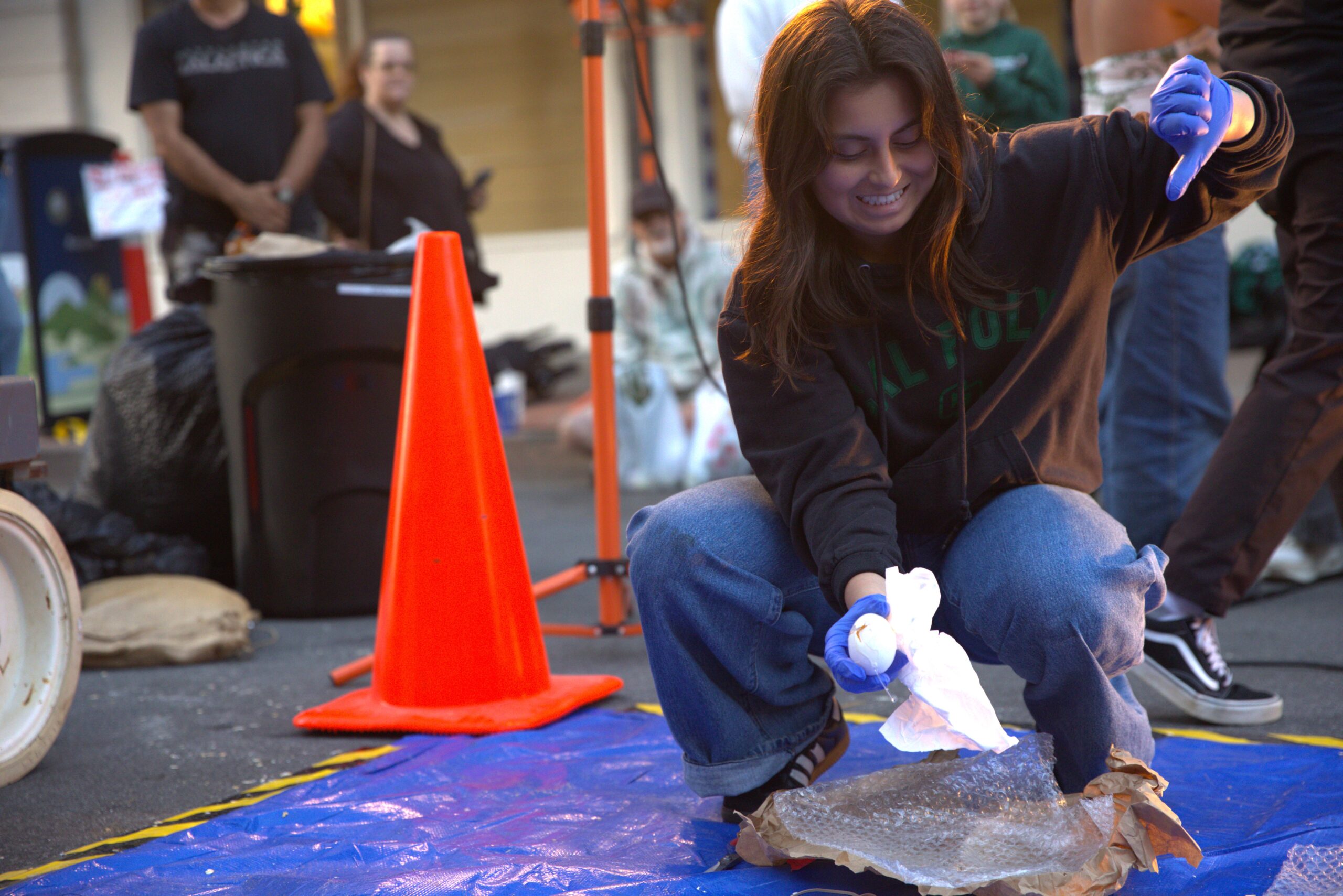 A Poly Pack members offers the crowd a thumb's down after revealing a cracked egg