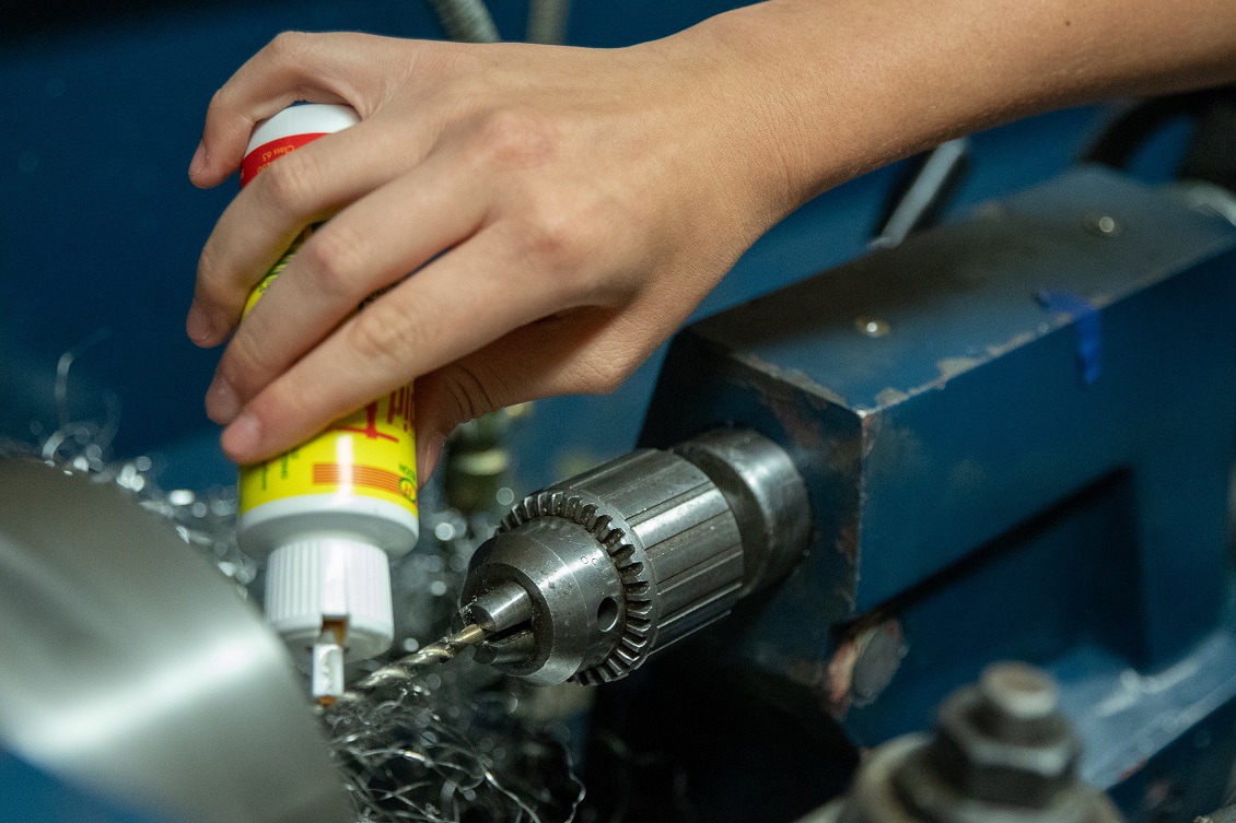 Close-up shot of a drill on a machine being oiled