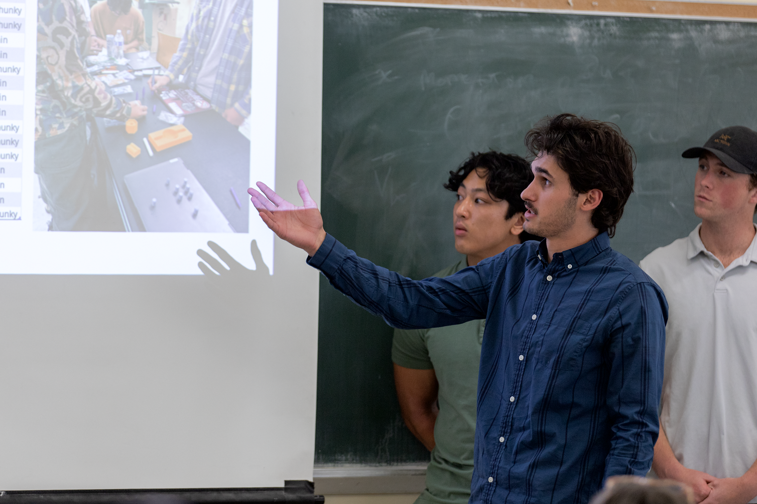 A student discusses his team's capstone project as it's projected on a screen