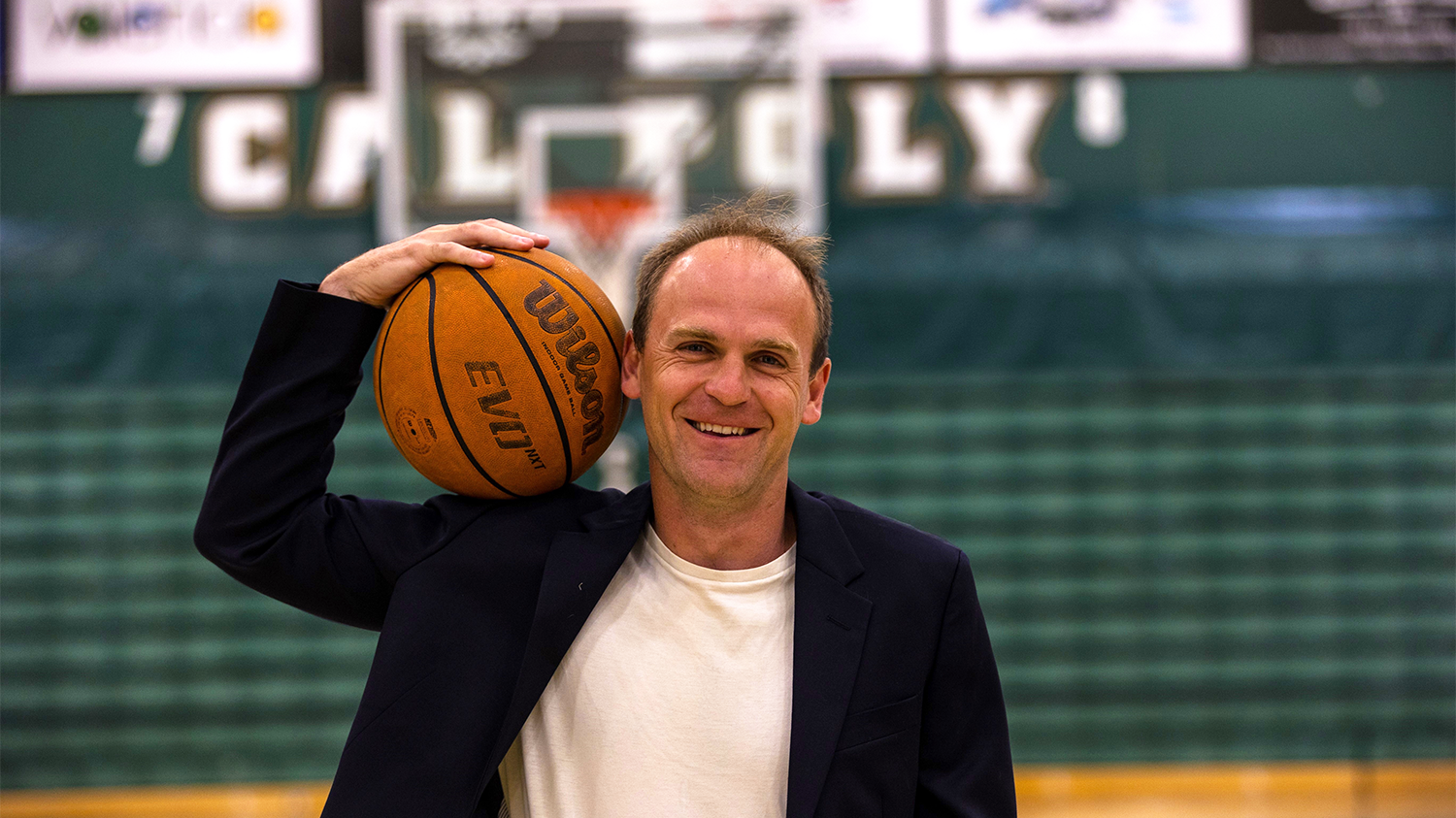 Joseph Kuehn poses for a portrait on the Mustangs basketball court