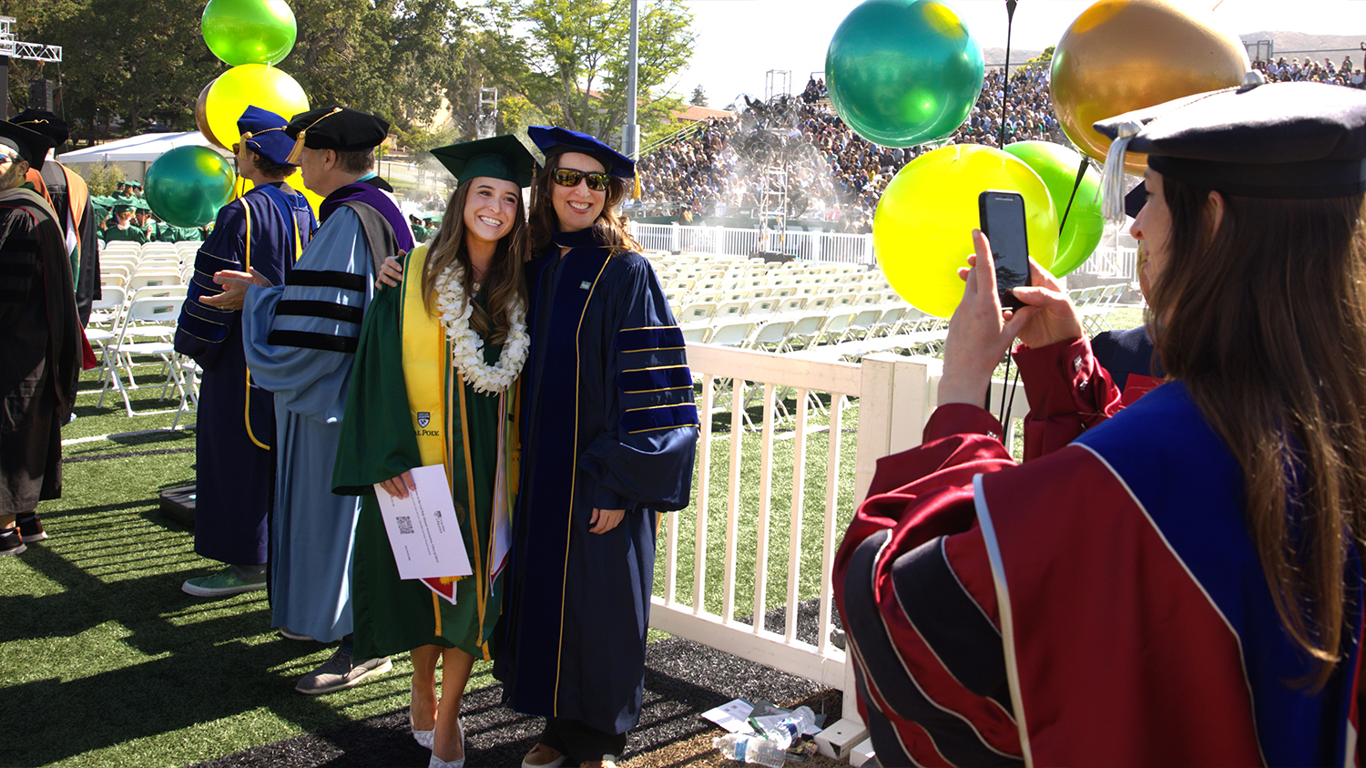 Gabrielle Gutierrez poses for a photo with a faculty member at commencement