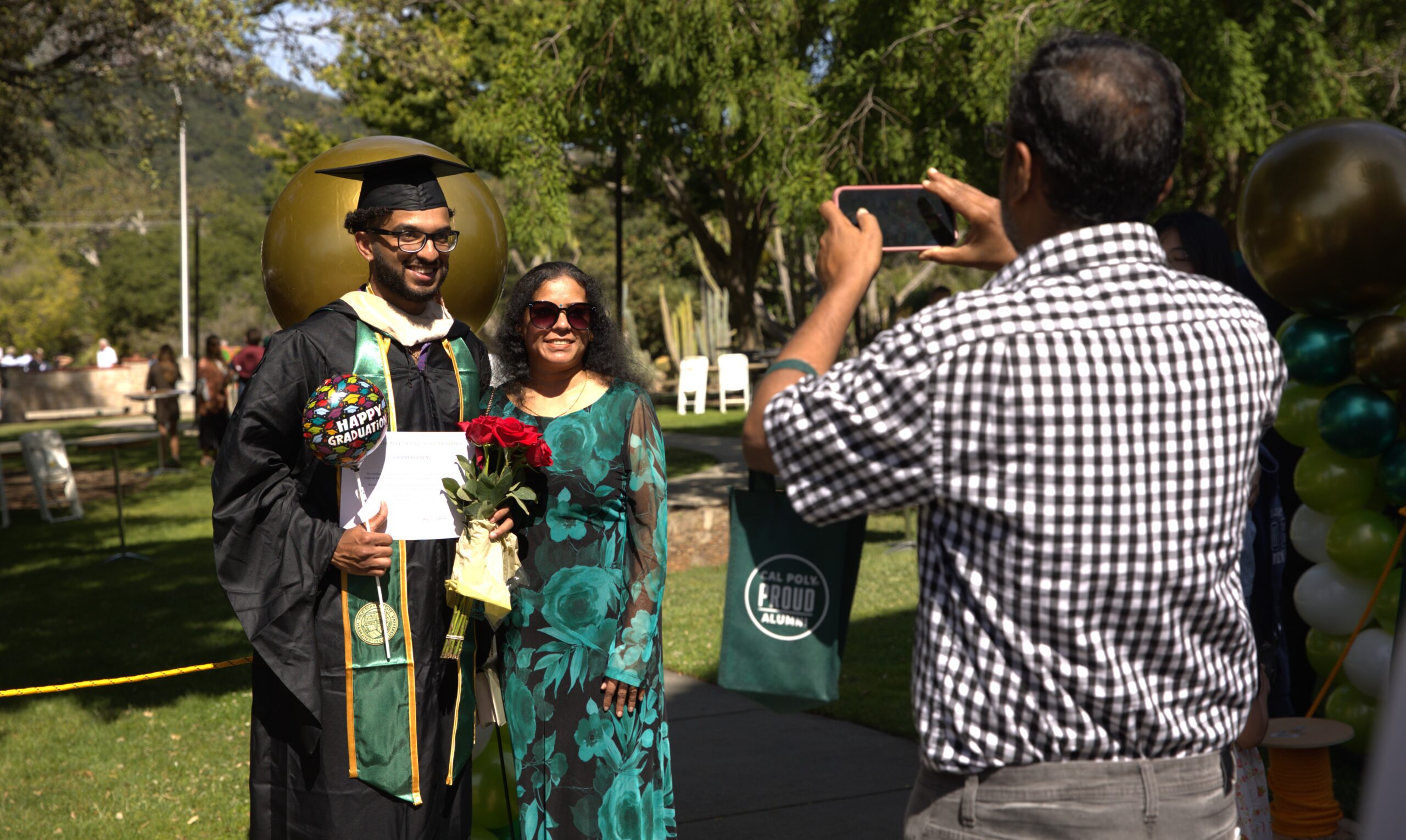 A father takes a photo of a graduating son